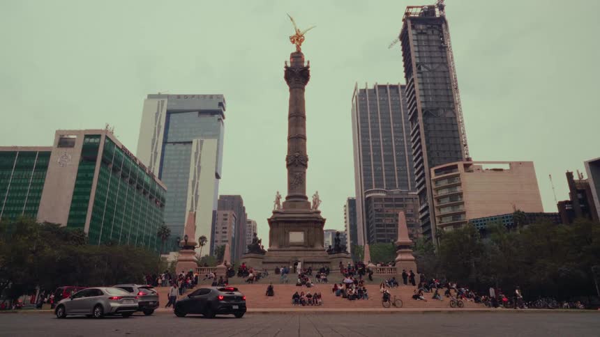 The iconic Angel of Independence monument stands tall amidst the bustling traffic and modern skyscrapers of Mexico City