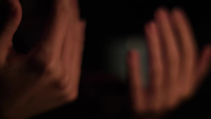 A person holding up their hands and warming them by the fire