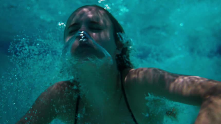A woman slowly rises to the surface