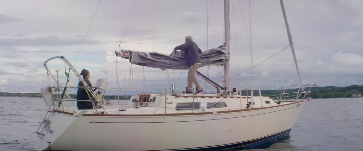 Man folds up sail on sail boat