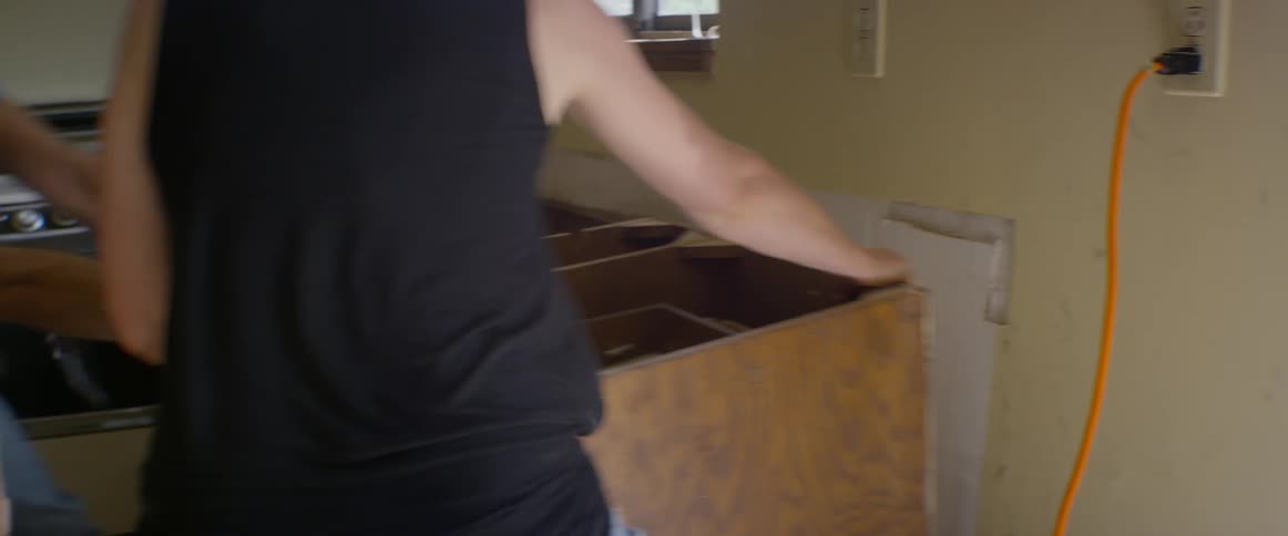 A man and woman demolish a kitchen