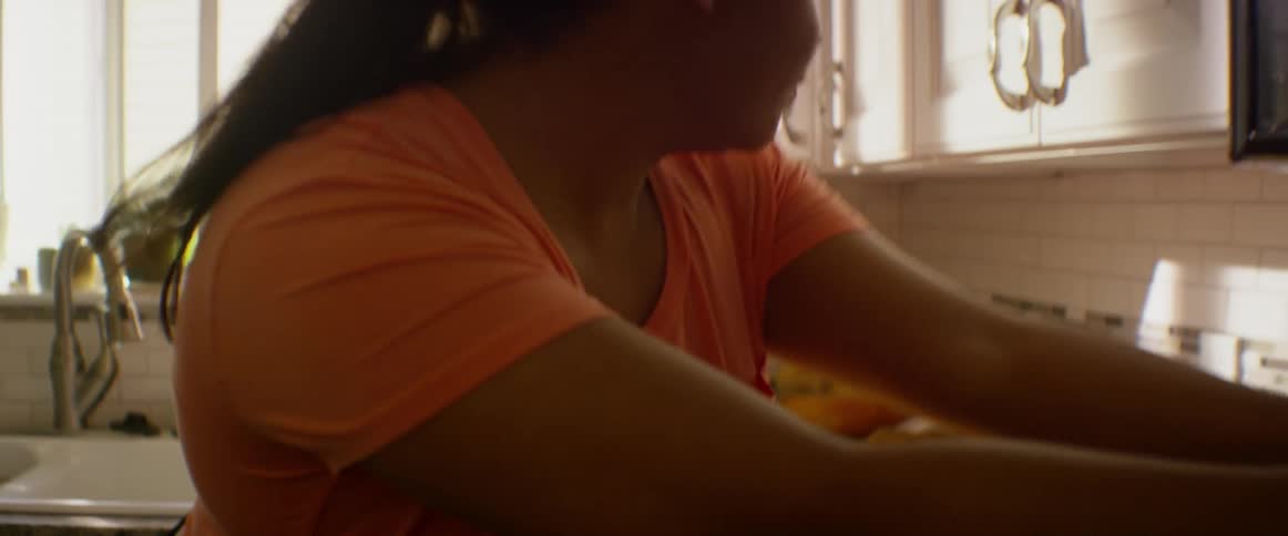 A woman is cutting carrots on a board