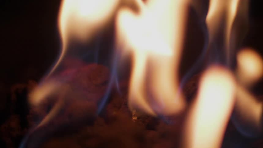 The flames of a fire jump and stretch upward