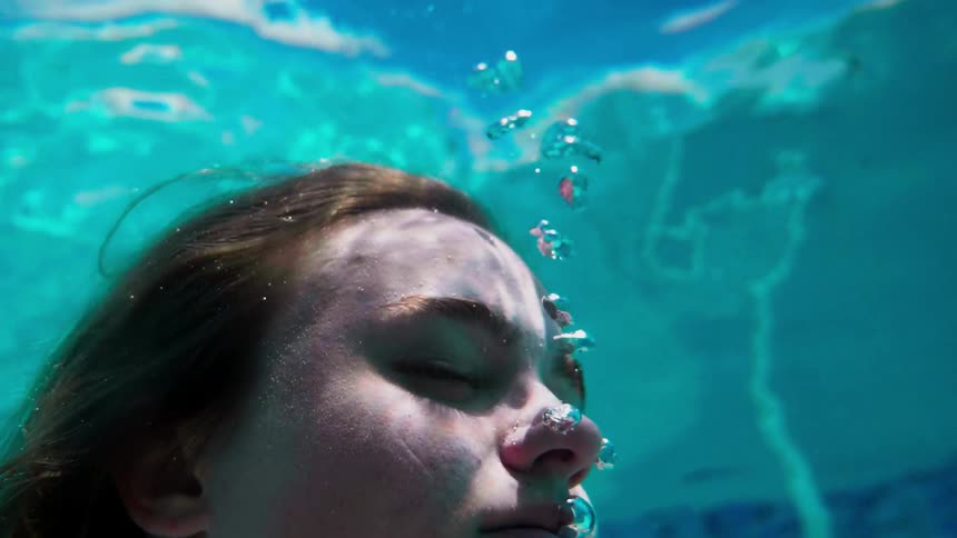 A woman is submerged in a swimming pool