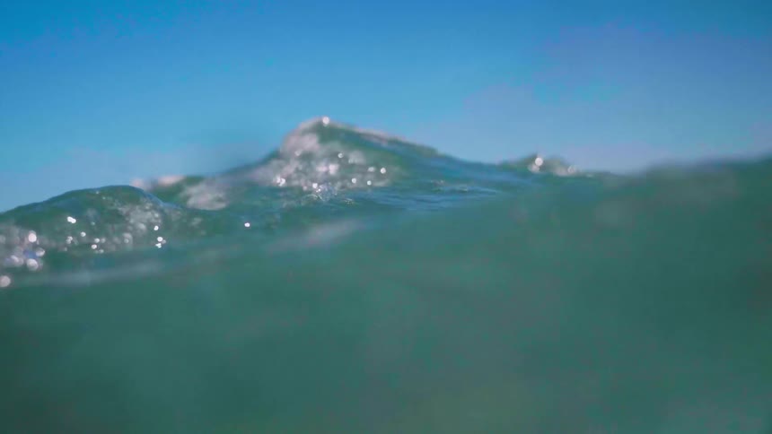 Ocean water flowing and spinning underwater on sunny day