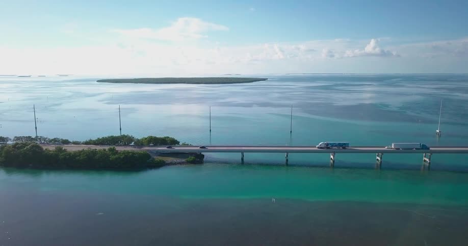 Vehicles drive on a bridge over ocean water