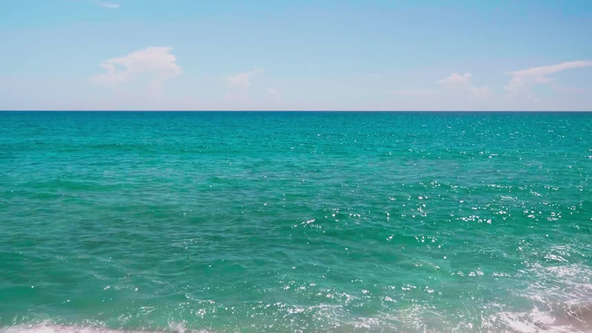 Turquoise ocean waters flowing and rippling on sunny day