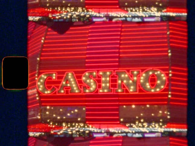 Classic Vegas CASINO red neon sign with flashing lights at night, on Super 8 film