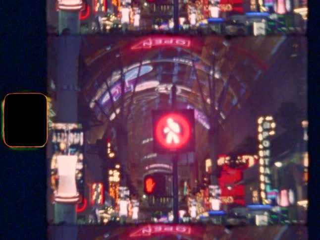 Zoom out from a “Don’t Walk” sign to reveal a crowded Vegas street with pedestrians and neon signs, on Super 8