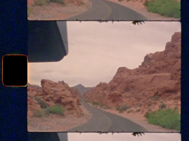 POV drive along a winding road through a stunning red rock desert canyon, on Super 8 film