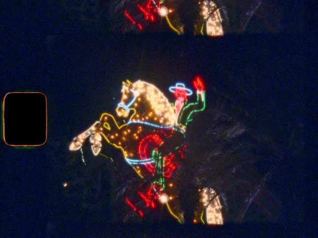 Iconic Vegas colourful cowboy neon sign at night, slow zoom in, shot on Super 8 film