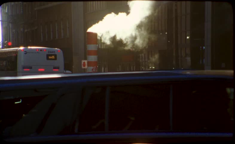 Steam billows from an iconic orange and white vent on a bustling New York City street in this vintage film footage