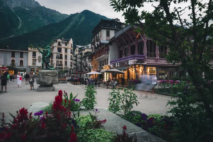 A vibrant timelapse of a bustling European town square in Chamonix, France, as evening falls over the scenic mountain village