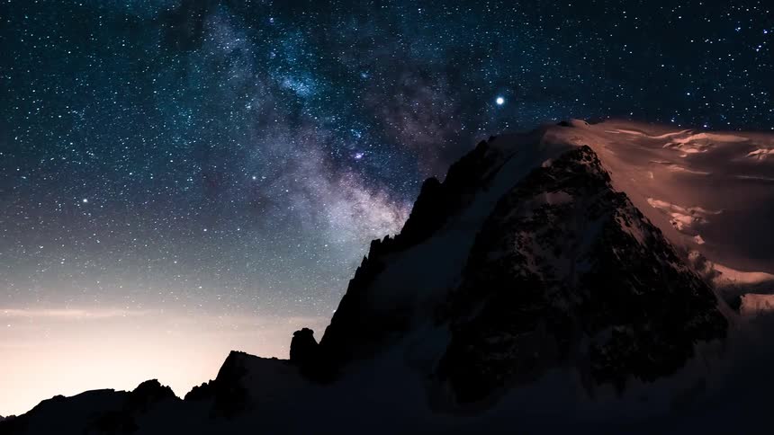Awe-inspiring time-lapse of the Milky Way galaxy moving across the night sky above a snowy mountain peak