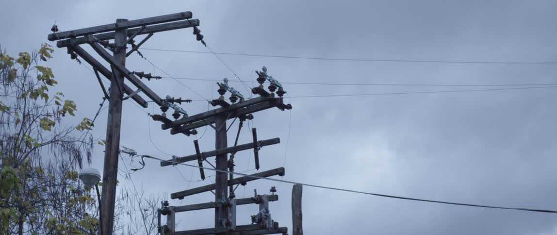 A view of power lines and poles under a cloudy sky