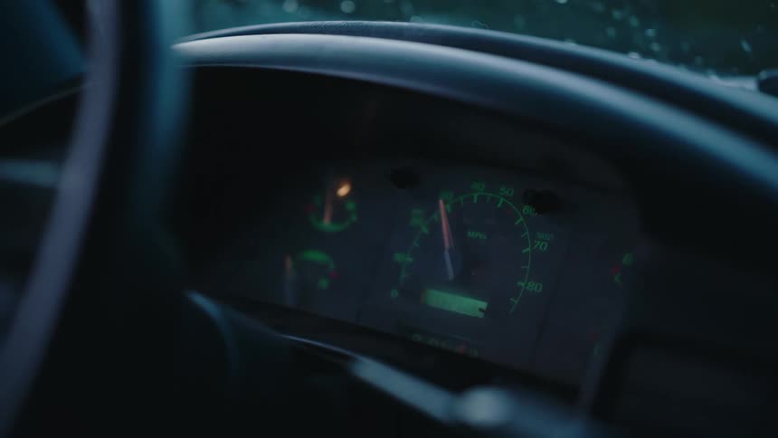 A close-up shot of a car's illuminated speedometer while driving at a steady speed in low light