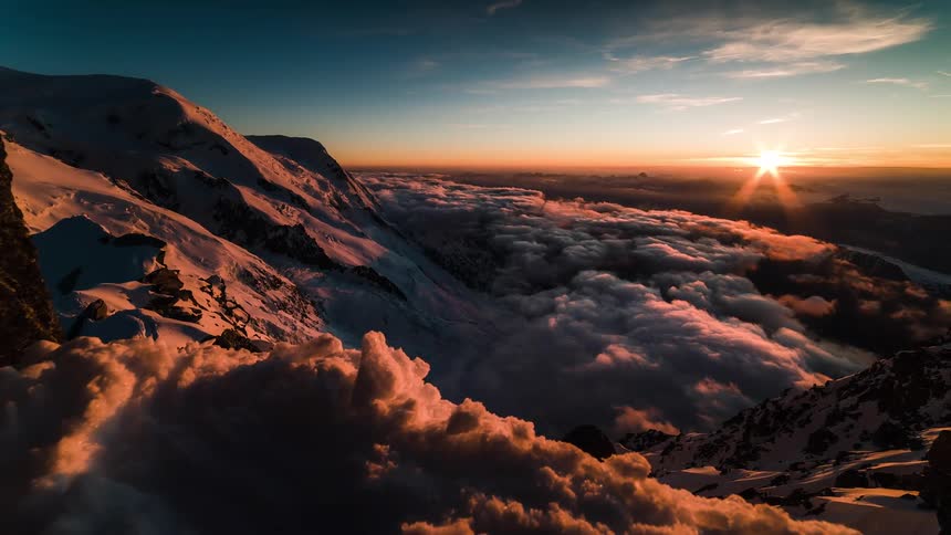 Epic time-lapse reveals a stunning sunrise over a snow-covered mountain, illuminating a vast sea of clouds with golden light