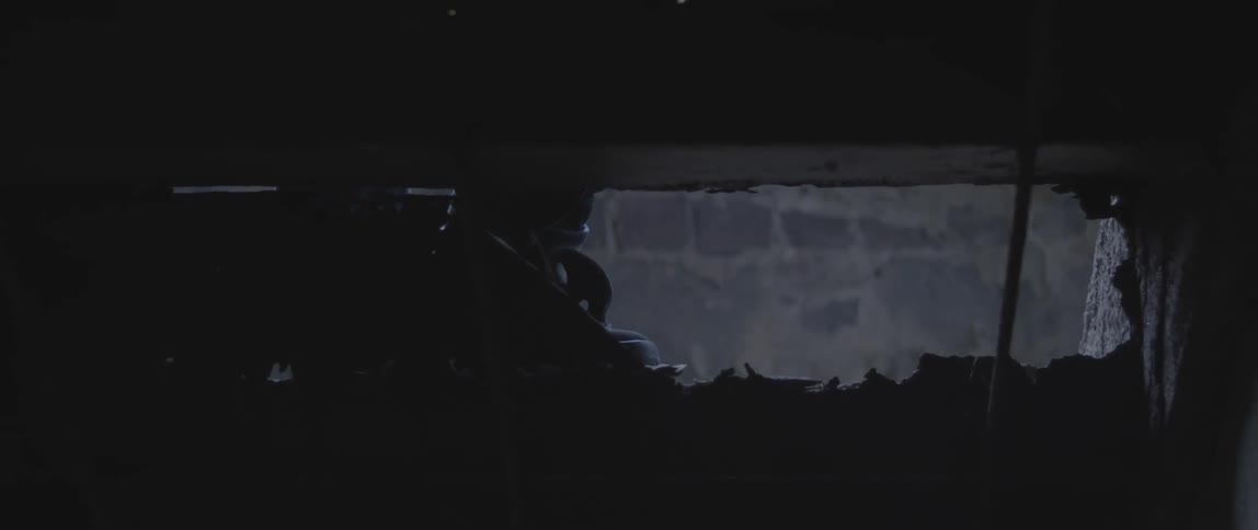 View from under a porch or stairs as a person wearing boots approaches and steps up