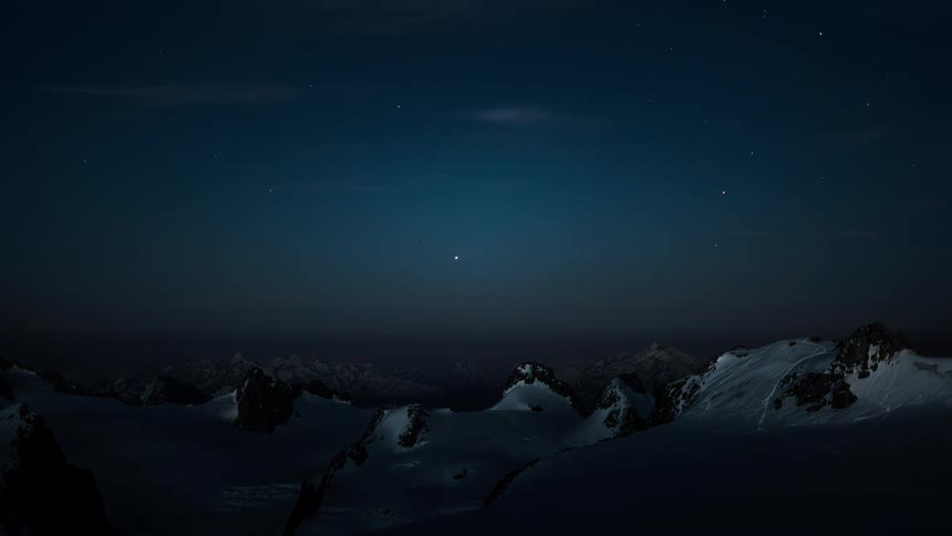 A stunning day-to-night time-lapse shows the Milky Way emerging over a vast, snowy mountain landscape