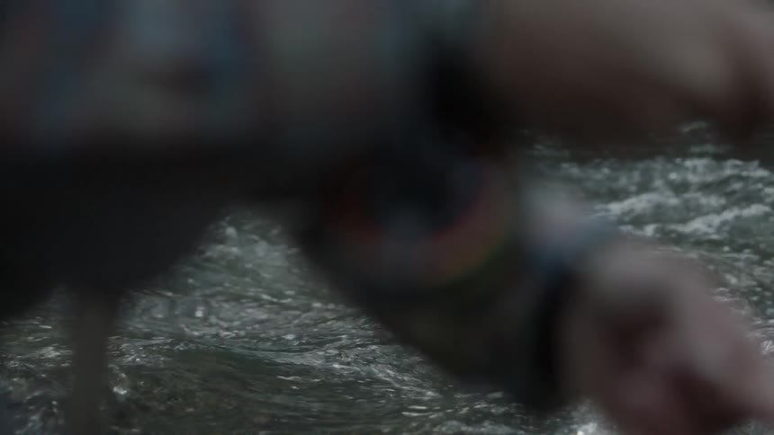 A person is fishing in a rough stream