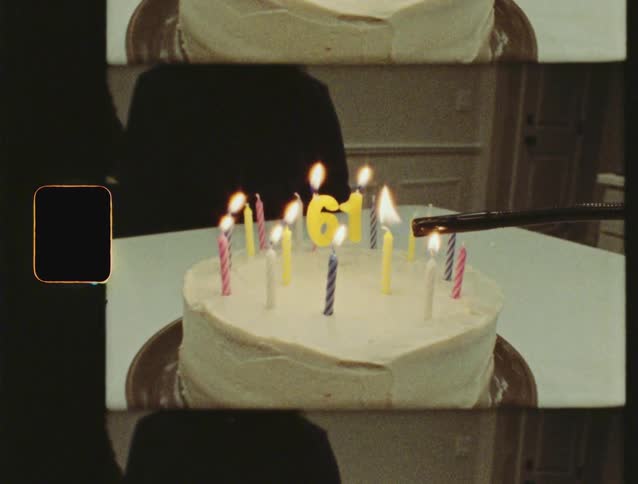 Authentic vintage film footage of candles being lit on a birthday cake for a 61st celebration