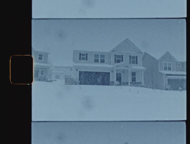 An authentic 8mm film scan captures a snowy suburban neighborhood with a vintage split-screen effect