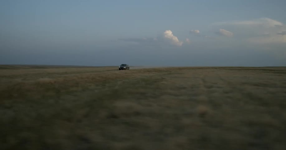 An suv drives across an open field