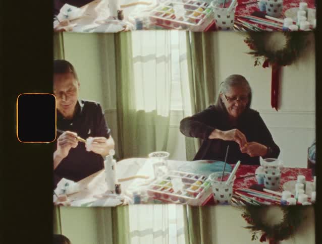 A family of three enjoys a quiet afternoon of painting and crafting together in a sunlit room, captured on vintage-style film