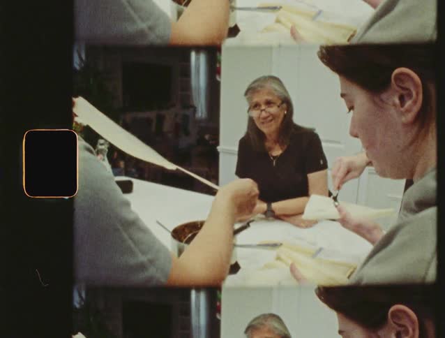 Vintage film footage shows a family bonding while making traditional tamales at home