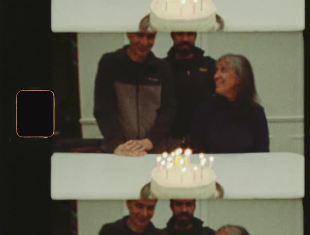 Vintage 8mm film captures a family celebrating a 61st birthday with a cake and candles