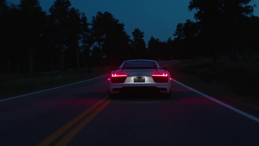 A car races down the road at dawn