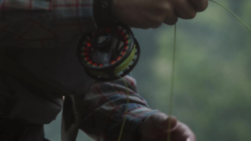 A man slowly wraps the line around while fishing