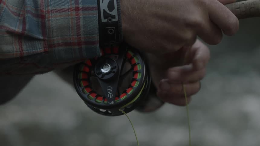 A person casts a fishing line in the water