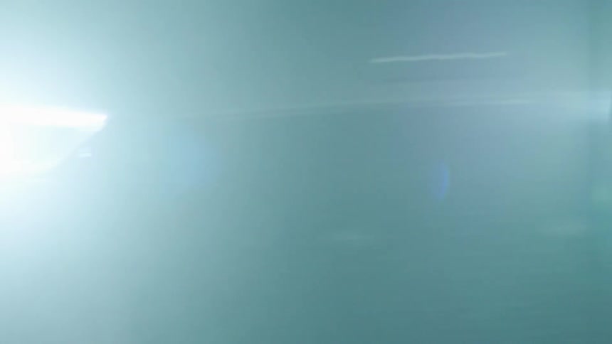 A vehicle with bright lights flashes by