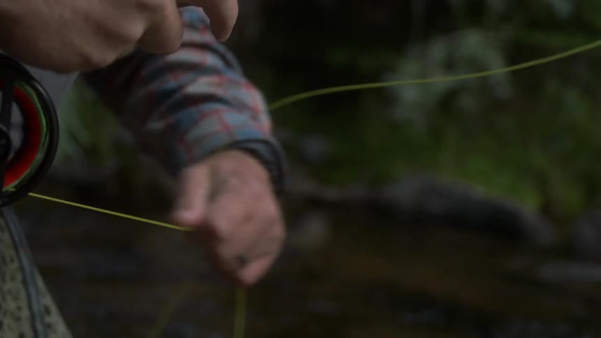 A man pulls out a lot of line from the reel on his fishing pole