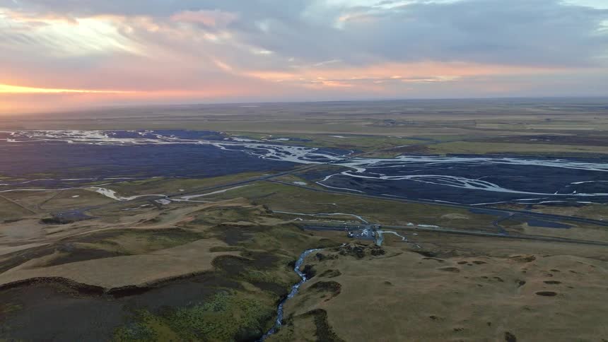 An epic aerial flight reveals the sprawling Icelandic highlands and a braided river system under a stunning sunset