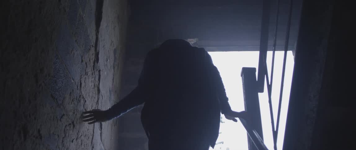 A person walks up stairs towards an open doorway