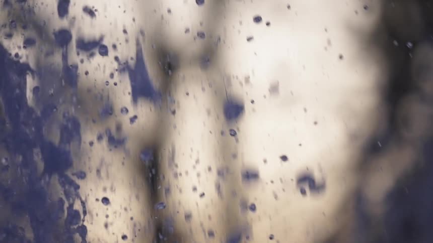 An abstract, vertical slow-motion close-up of water droplets splashing from a fountain