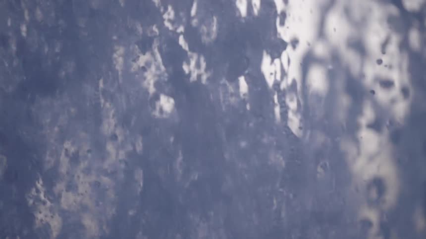 A mesmerizing abstract extreme close-up of water bubbling upwards in super slow motion