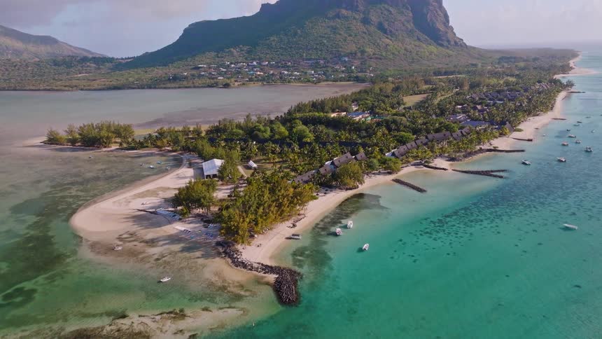 A stunning aerial view reveals the beautiful tropical paradise of Le Morne peninsula in Mauritius, with its clear turquoise lagoon and iconic mountain