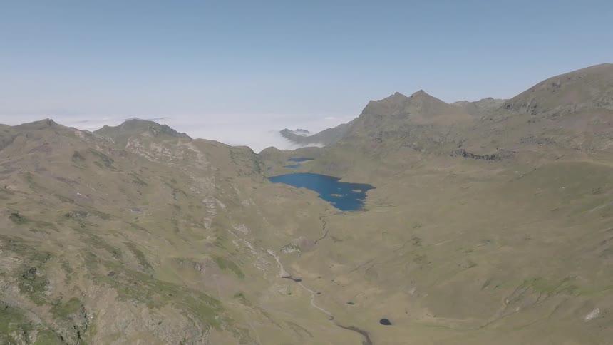 A breathtaking static aerial view of a vast mountain valley with serene blue lakes, floating above a sea of clouds