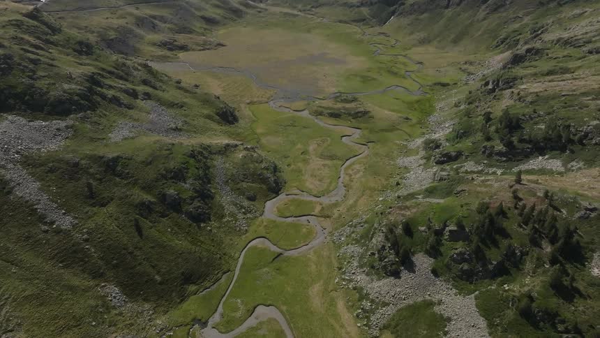 Aerial view of a beautiful winding river flowing through a lush green mountain valley