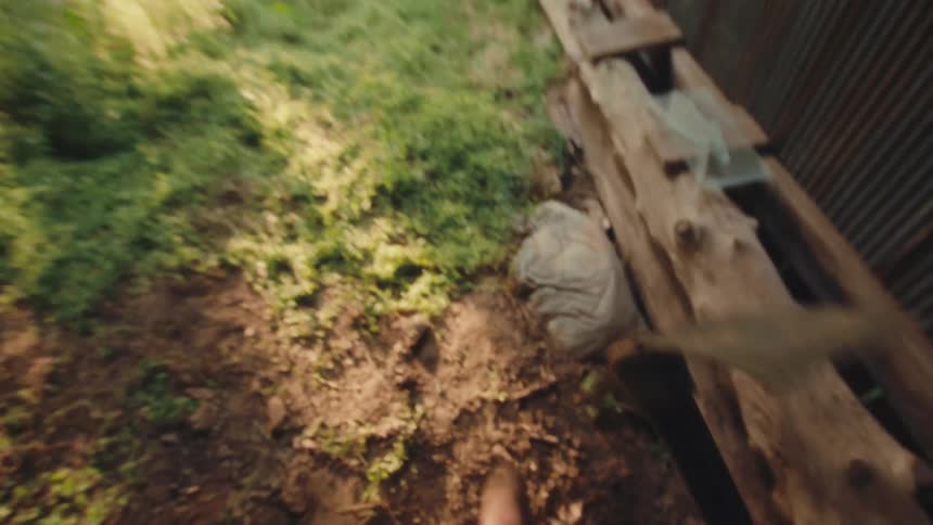 A first-person view of a person grabbing a pickaxe from a rustic wooden ledge and walking outside into a grassy field