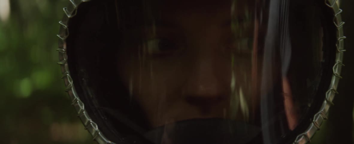 A woman in a mask looks around in the woods
