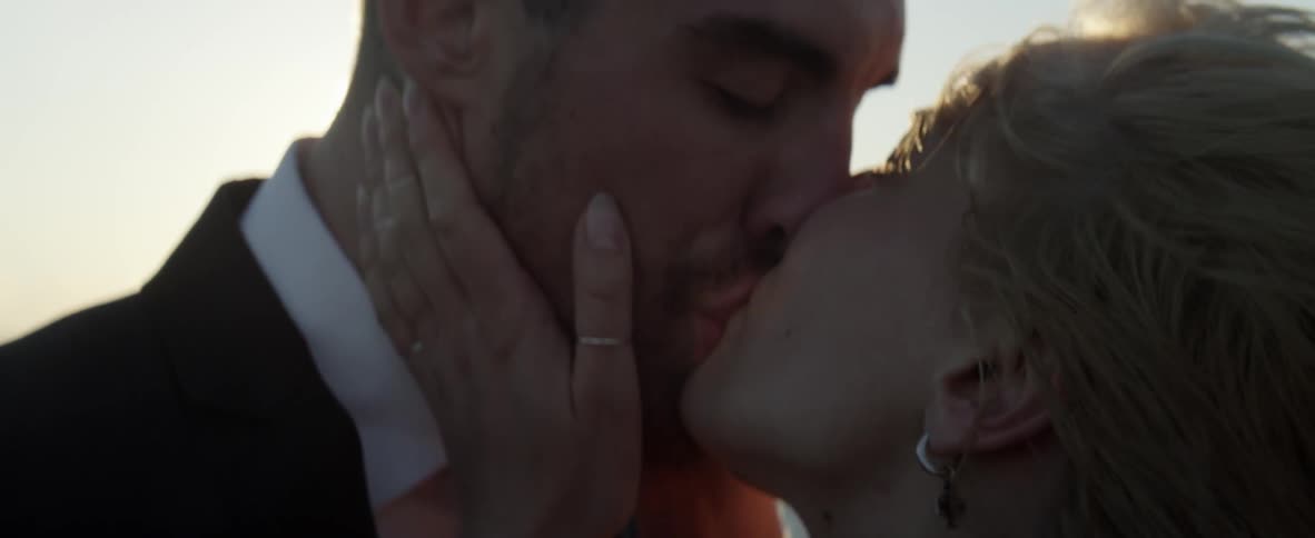 A couple kiss on a windy day
