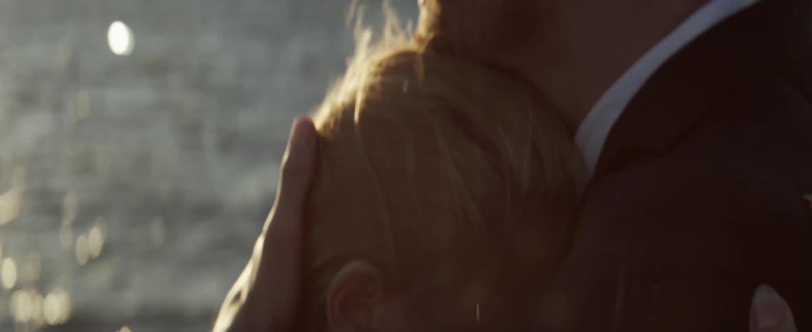A man is hugging a woman by the water