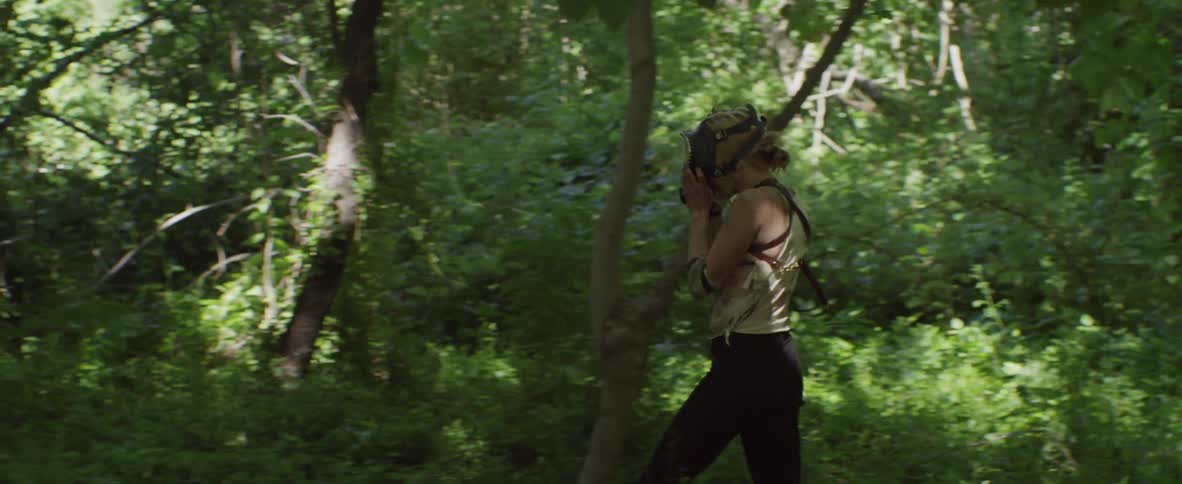 A masked woman walks in the woods