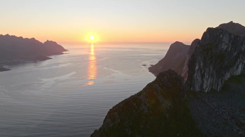 A breathtaking aerial view reveals a stunning mountain fjord landscape during a golden sunset in Norway