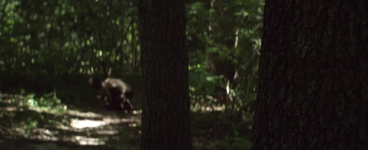 A woman leans against the tree and runs off being chased