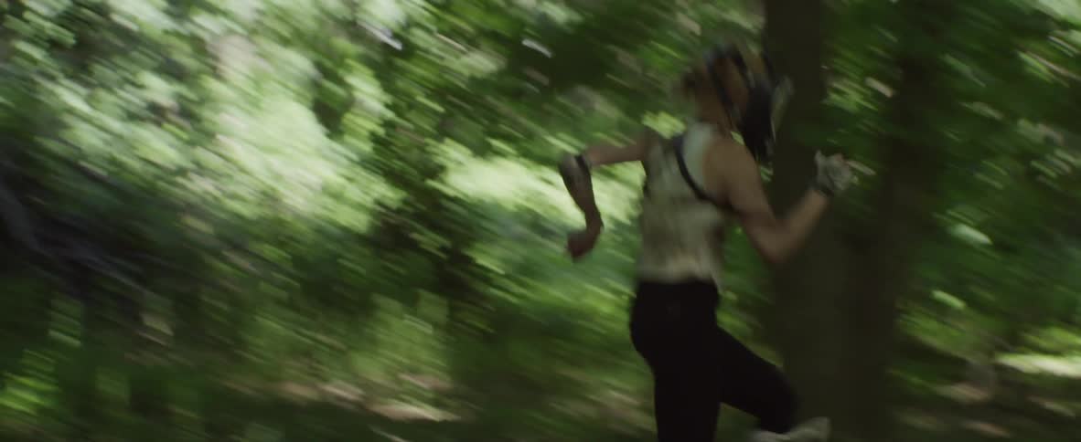 Women wearing full face mask being chased through forest